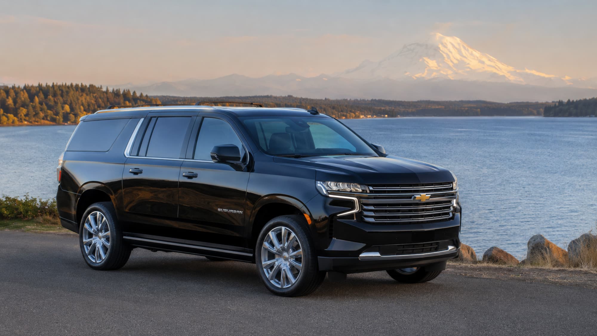 The Suburban beside a lake with Mount Rainier behind it
